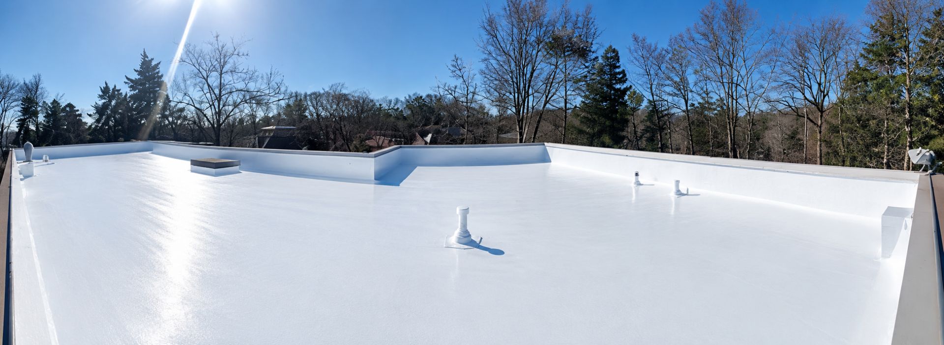 Roofing crew applying reflective coating to a commercial flat roof in Atlanta